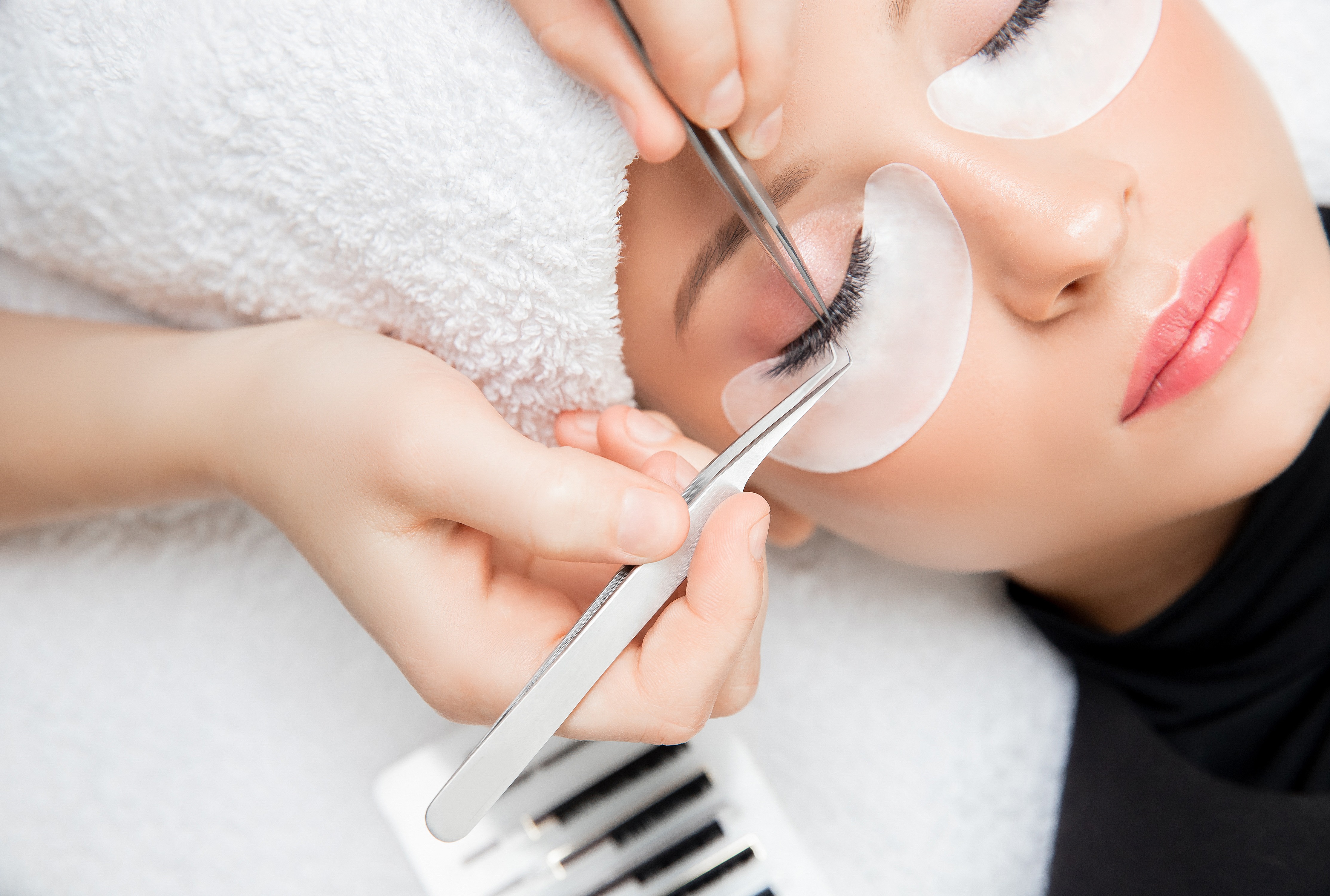 Wimpernverlängerung. Meister Pinzette fake lange Wimpern schöne weibliche Augen